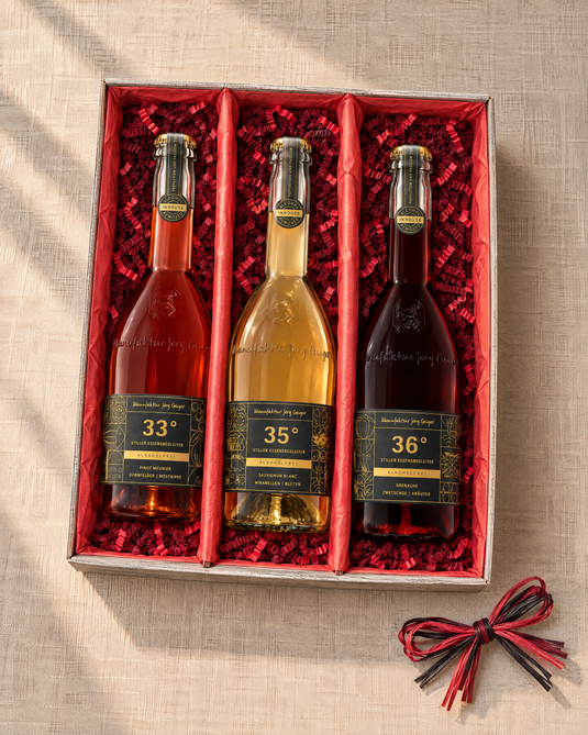 Grad°Wanderung Geschenkset mit drei alkoholfreien Cuvées in einer offenen 3er-Kartonage mit rotem Papier und rotem Sizzlepack